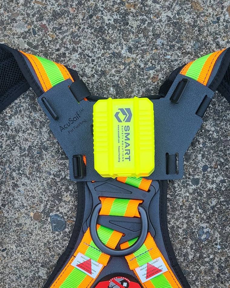 Camera mount positioned above the D-ring on a padded harness, centered between the shoulder straps